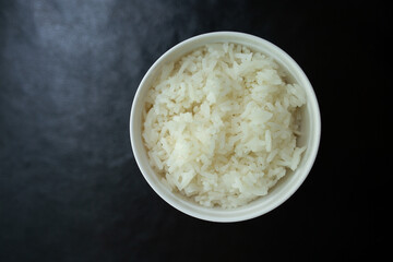 Cooked rice or (Rice) in a bowl on a black background