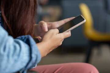 Obraz na płótnie Canvas Asian young woman using smartphone in coffee shop