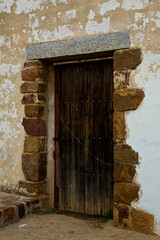 Puerta vieja de madera con piedras formando marco