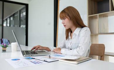 Fototapeta na wymiar Portrait of businesswoman working on laptop in her workstation. 