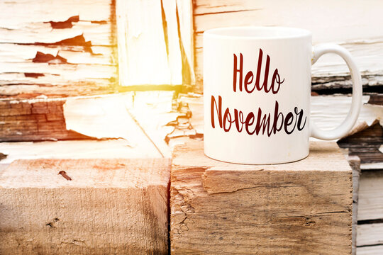 A Cup of coffee with Hello November text above wooden cube