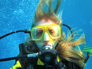 Girl with long red / blond hair is diving in the sea. Concept of active lifestyle, sports activities, recreation.