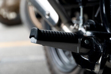 Close up footpeg of motorcycle. Stop in parking lot.