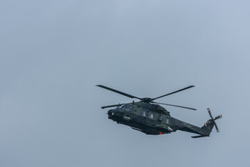 Fototapeta na wymiar flying green military helicopter at a air show