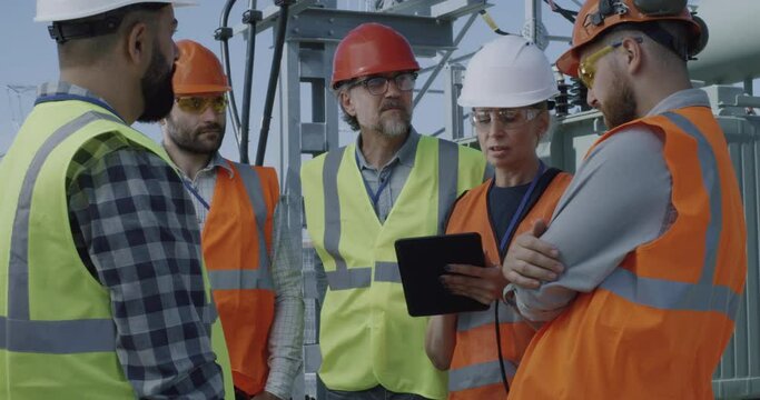 Female engineer discussing data on tablet with men
