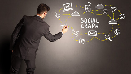 businessman drawing social media icons with SOCIAL GRAPH inscription, new media concept