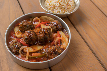 Homemade meatballs with vegetables and vermicelli rice on the side. On the wooden background. Closeup. Eat healthy food. Cooking at home. Mouth-watering meal. 