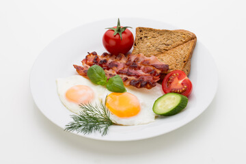 Fried eggs with bacon on the wooden table.