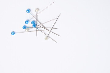 Glass head pins or heat-resistant pins stacked together on a white background.