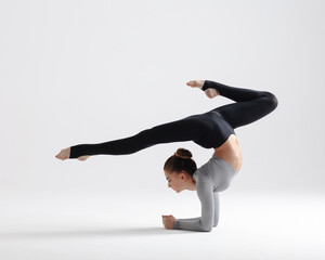 Naklejka premium Young gymnast girl stretching and training