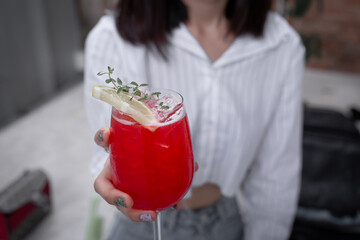 Close up of young woman drinking strawberry cocktails at outdoor on restaurant.