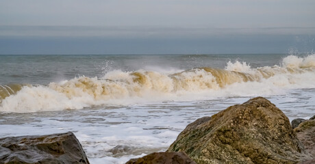 Barrel waves crashing in to the beach during high tide on  the Norfolk Norfolk coast.