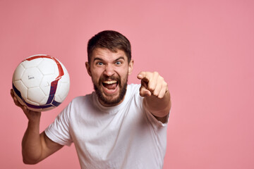 Man with a soccer ball on a pink background energy gesticulate with his hands coach emotions model