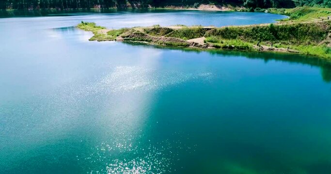 Russian landscape. Beautiful views of the clear waters of the lake formed as a result of mining, taken from a quadcopter on a summer day. A bird's-eye view.