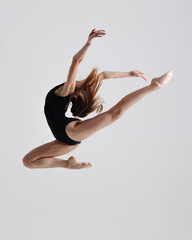 Fototapeta premium Young gymnast girl stretching and training