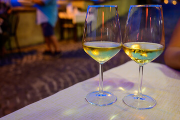 Two glasses of cold dry white wine served outdoor in cafe at night in Italy