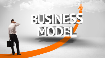 Rear view of a businessman standing in front of BUSINESS MODEL inscription, successful business concept