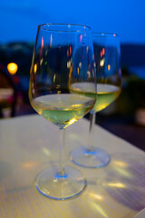 Two glasses of cold dry white wine served outdoor in cafe at night in Italy