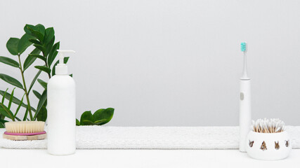 a beauty care background of a cream, a toothbrush, a green flower and the ear sticks