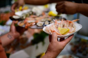 Catch of the day, waiter with fresh shrimps and sea food on ice in fish restaurant in Terracina, Italy