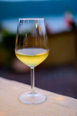 Glass of cold dry white wine served outdoor in cafe at night in Italy