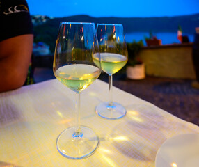 Two glasses of cold dry white wine served outdoor in cafe at night in Italy