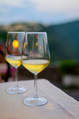 Two glasses of cold dry white wine served outdoor in cafe at night in Italy