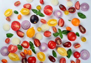 lots of tomatoes, onion slices and basil leaves isolated on a white background