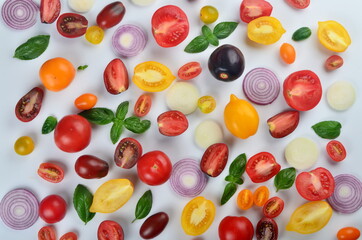 lots of tomatoes, onion slices and basil leaves isolated on a white background