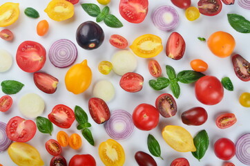 lots of tomatoes, onion slices and basil leaves isolated on a white background