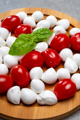 Italian food, fresh fresh green basil, white mini mozzarella cheese and red cherry tomatoes