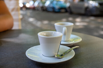 Drinking of strong black espresso coffee on outdoor terrace in cafe