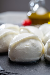 Tasty italian food, fresh white buffalo mozzarella soft cheese balls from Campania, tomatoes, fresh basil and olive oil