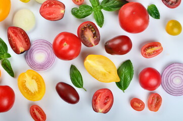 lots of tomatoes, onion slices and basil leaves isolated on a white background