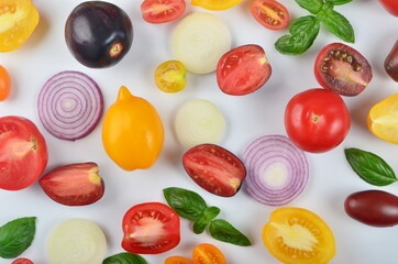 lots of tomatoes, onion slices and basil leaves isolated on a white background
