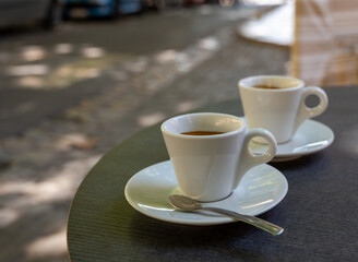 Drinking of strong black espresso coffee on outdoor terrace in cafe