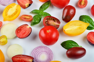 lots of tomatoes, onion slices and basil leaves isolated on a white background