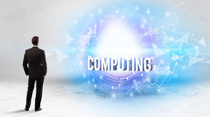 Rear view of a businessman standing in front of COMPUTING inscription, modern technology concept