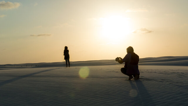 Silouhette of man and woman on the sand of the dunes of lencois maranhenses, Maranhao, Brazil