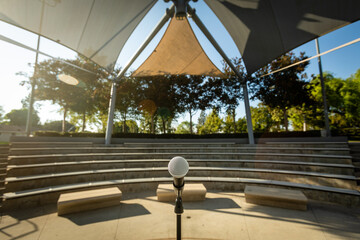 Microphone Stand in Empty Amphitheater with No People Outside at Sunset for Comedy Show or Live Entertainment - obrazy, fototapety, plakaty