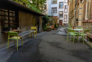 Fototapeta na wymiar Hinterhof mit bunten Stühlen und alten Bäumen in einer deutschen Studentenstadt, Heidelberg
