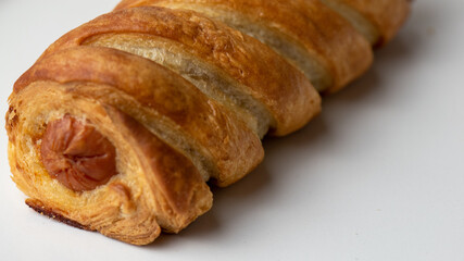 close up of a sausage roll on white background 
