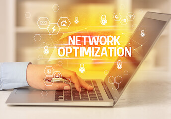 NETWORK OPTIMIZATION inscription on laptop, internet security and data protection concept,...
