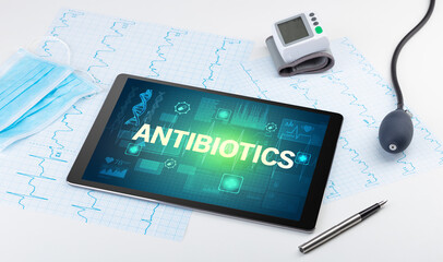 Tablet pc and medical stuff with ANTIBIOTICS inscription, prevention concept