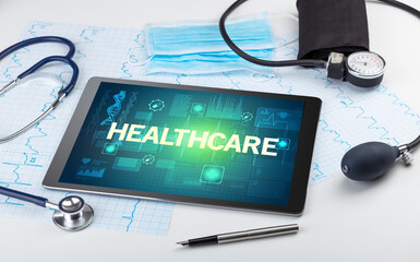 Tablet pc and medical stuff with HEALTHCARE inscription, prevention concept