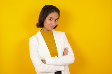 Waist up shot of beautiful self confident cheerful young woman entrepreneur has broad smile, crosses arms, happy to meet with colleague, dressed in fashionable clothes.