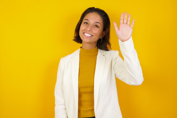 Portrait of cheerful, outgoing friendly-looking young woman wearing casual clothes raise one hand...