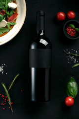 Red wine on the table with Italian food, empty label concept