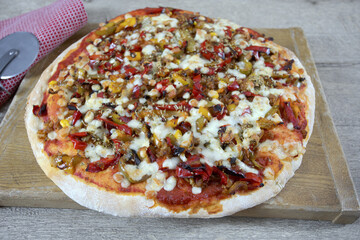 pizza entière au poulet et poivrons sur une planche à découper