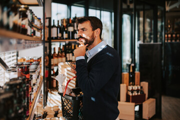 Handsome middle age man buying some healthy food and drink in modern supermarket or grocery store....